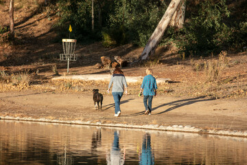 Obraz na płótnie Canvas A Family Enjoying a Beautiful Day in a Recreational Lake Park Taking a Walk