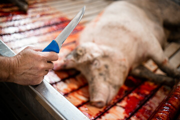 Fototapeta Close up view of butcher's knife and slaughtered pigs in slaughterhouse. obraz