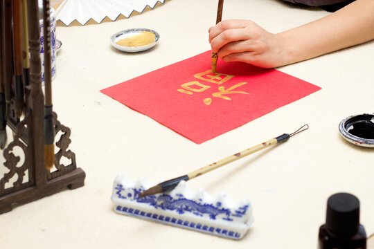chinese calligraphy Master writing new year golden character Fu means Blessing, Good Fortune, Luck