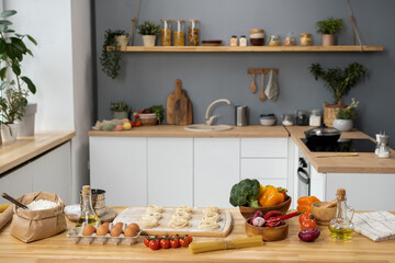 Wooden kitchen table with fresh ingredients for dough, traditional italian pasta and homemade pastry
