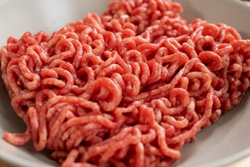Minced beef or pork in white porcelain bowl prepared for cooking traditional italian pasta with meat or homemade pastry