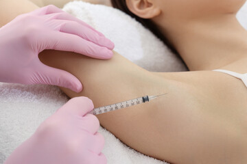 Obraz na płótnie Canvas Cosmetologist injecting young woman's armpit, closeup. Treatment of hyperhidrosis