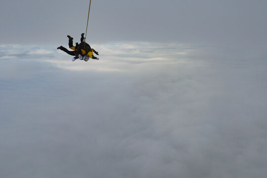 Tandem skydiving. Tandem jump in the cloudy sky.