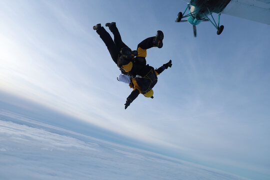 Tandem skydiving. Tandem jump in the cloudy sky.