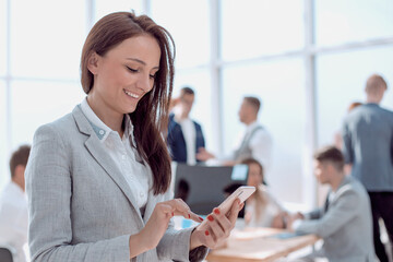 smiling business woman reading a message on her smartphone