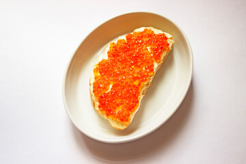 Two sandwiches with red caviar on a porcelain plate