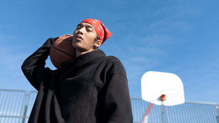 Asian man with basketball on playground