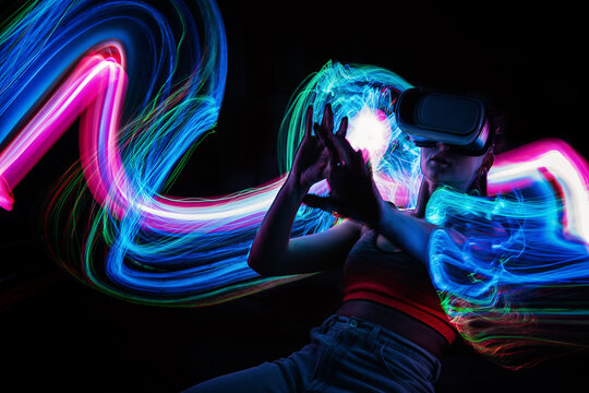 Metaverse digital Avatar, Metaverse Presence, digital technology, cyber world, virtual reality, futuristic lifestyle. Woman in VR glasses playing AR augmented reality NFT game with neon blur lines
