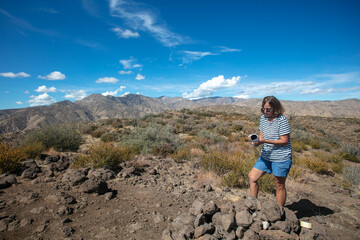 Fototapeta premium A Beautiful Mature Woman on a California Summit Filling out the Summit Log after a Great Hike to the Top