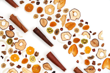 Above view of neatly stacked fruit lozenge different colors and almonds, orange, dried apricot, raisins, walnuts, dried apples and kiwi on white background. Concept of healthy snacks. 