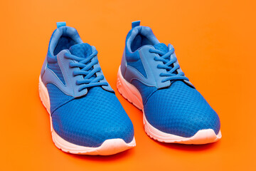 sporty blue sneakers. shoes on orange background. shoe store. shopping concept.