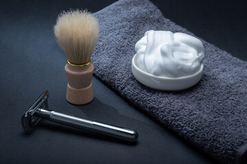 Closeup of men's toilet accessories: a razor, a shaving brush and some shaving foam.