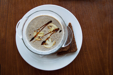 Cream soup puree with mushroom in a bowl on wooden background..Vegan food. Dietary menu. Top view.