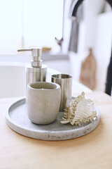 Soft light bathroom decor in gray color, towel, soap dispenser, shell, accessories on pastel gray background. Elegant decor bathroom interior. Selective focus