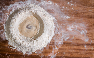 Ingredients for bread and decoration of fresh flour and desk flour.