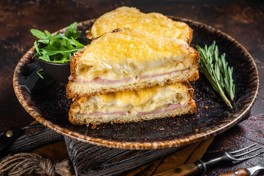 Croque Monsieur toasted sandwich with Cheese, Ham, Gruyere and Bechamel Sauce. Dark background. Top view