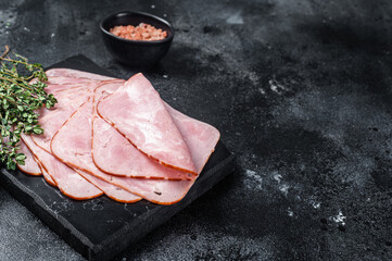 Squared slices of lean pork ham. Black background. Top view. Copy space