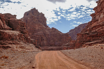 empty highway surrounded by red weathered mountains, Wadi Rum desert, Jordan