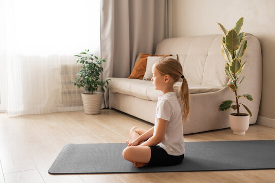 Kids yoga at home concept, litle girl meditation