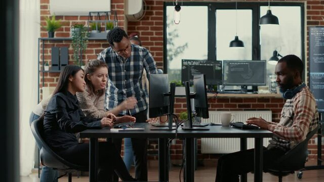 Junior developers collaborating on group project compiling algorithm asking senior programer for help while intern joins the discussion. Software engineers brainstorming ideas looking at screens.