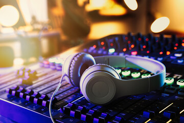 Headphones on professional mixing console in radio studio, closeup