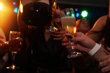 Partial view of happy young friends drinking champagne. Party at the nightclub