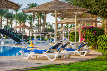 Naklejka na ściany i meble Hurghada, Egypt. Egyptian garden with palm trees in hotel .Swimming pool and accommodation at tropical resort. Buildings, swimming pools and a recreation area by the red sea. All iclusive holidays.