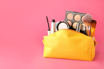 Cosmetic bag with makeup products and accessories on pink background. Space for text