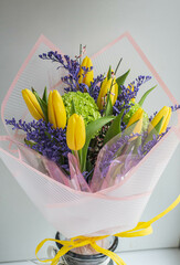 fresh spring bouquet with yellow tulips and violet flowers