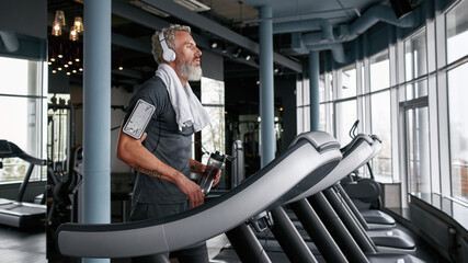Fototapeta na wymiar Tired man finished cardio exercises on treadmill