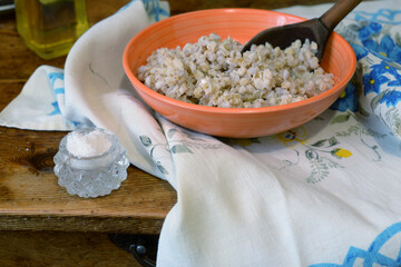 barley grits porrige with wooden spoon in bowl on table