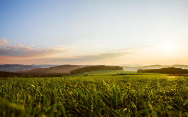 Landschaft bei Sonnenuntergang mit Dunst über den Feldern