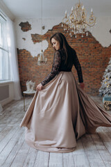 Fototapeta premium The girl is beautiful in a dark beige dress smile shows the dress