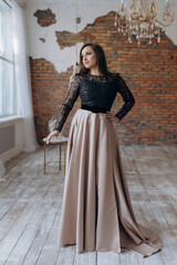 The girl is beautiful in a dark beige dress smile shows the dress