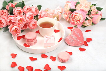 Concept for Valentine's Day or Women's Day, Mother's Day, banner. Greeting card, pink roses, tea and hearts and marshmallows on a light background, congratulations on the holiday, birthday