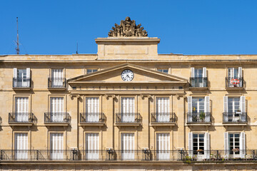 Front facade with clock on top at new square in Bilbao built in 1851. Neoclassical architectue style concept. Translation: Basque language academy