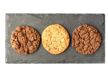 Top view of different varieties of granola cookies on a stone board for serving.
