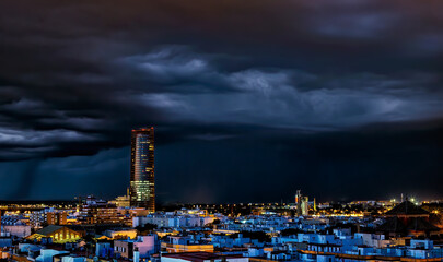 Fototapeta na wymiar Spectacular view of Historic Triana Neighborhood and Seville city skyline a stormy night. Seville city, Tradition and Modernity