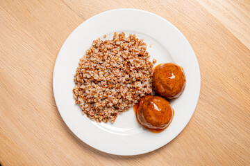 buckwheat with meatballs on the white plate