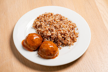 buckwheat with meatballs on the white plate