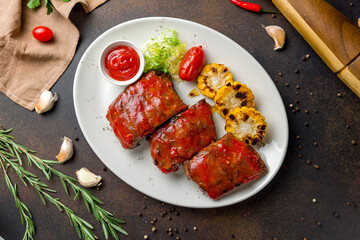 fried pork ribs in chili sauce with fried corn top view on dark brown table