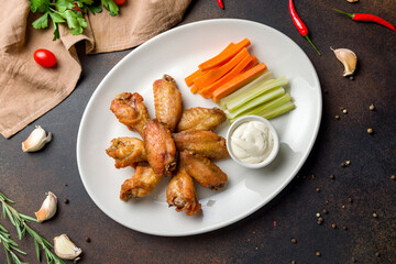 Buffalo chicken wings with blue cheese sauce on dark brown concrete table top view