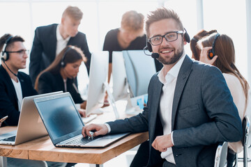 businessman in a headset sitting at an office Desk.