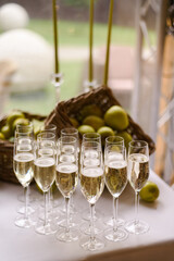 glasses of champagne on table. Event and catering agency organization modern wedding in nature style. Welcome zone at the wedding for guests with champagne and fruit