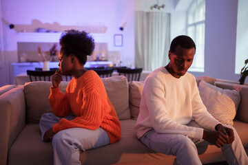 Relationship fights. Upset black american family couple sit back to back on sofa at home and not...