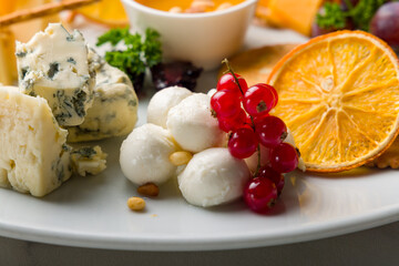 mozzarella cheese in balls on plate with berries macro close up