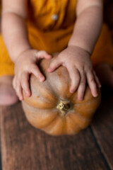 yellow small pumpkin in the hands of a child