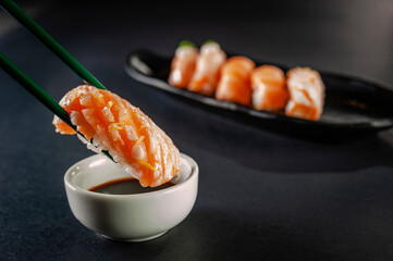 Truffle salmon onigiri on chopsticks.