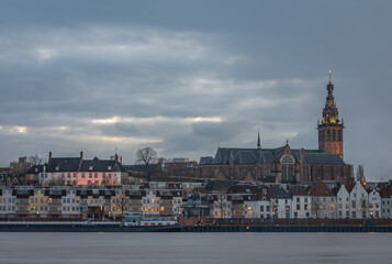Skyline of dutch city Nijmegen at dusk with majestic Stephen's Church along the Waal river