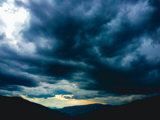 Naklejka premium thunderstorm with wild black clouds in the mountains with a bright silver lining, dolomites, south Tyrol, Italy